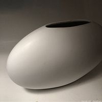 Side view of the matte cream modernist vase showing its smooth surface and narrow opening.