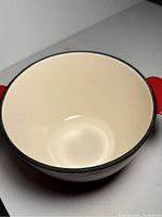 Close-up of the inside cream-colored interior of the cast iron container.