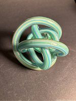 View of knotted glass sculpture showing intertwined colorful ribbons of glass