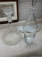 Two glass decanters on marble surface showing overall shapes