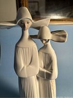 Close-up of two nuns figurine showing details of faces, posture and attire.