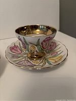Rosina teacup showing floral tulip motif and gold interior alongside saucer