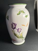 Side view showing purple tulip flower design on white ceramic with green trim at rim and base.