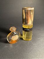 Wide view of both perfume bottles showing Le Dix by Balenciaga with gold capped tall bottle and small round Houbigant Quelque Fleurs bottle with floral label.