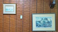 Smaller and larger Keirstead prints hanging on wood panel wall, showing size difference and framing