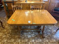 Top-down view of rectangular wooden trestle table showing surface and part of four chairs around it