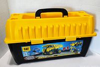 Photo showing yellow and black plastic toolbox carry case with handle and CAT 3 in 1 Machine Maker label