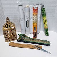 Full lot showing ceramic open lattice candle holder, ceramic dragon incense stick holder, multiple incense packs, wooden holder, and tweezers.