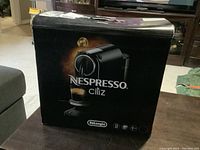 Front view box showing De'Longhi EN167 B Nespresso coffee maker image and branding
