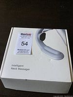 Closed white box featuring an image of the massager and the label 'Intelligent Neck Massager'.