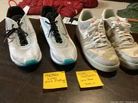 Pair of Nike Air Max 2090 Pure Platinum sneakers with black laces next to Nike Air Force 1 Low camo sneakers, both size 11.