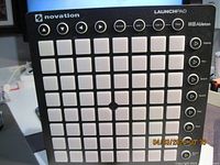 Novation Launchpad MK2 showing white pads and control buttons on black unit, taken on a table.