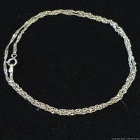 Full view of the 18 inch sterling silver chain laid out on black background showing the chain design and length.