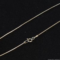 Close-up of the sterling silver chain necklace showing the lobster claw clasp and chain texture.