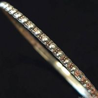 Close-up photo showing the beaded design pattern on sterling silver bangle against a black background.