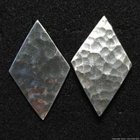 Photo showing two sterling silver diamond-shaped earrings with a hammered finish on a black background.