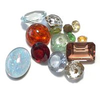 Close-up of varied genuine loose gemstones showing different colors, cuts and sizes in the lot.