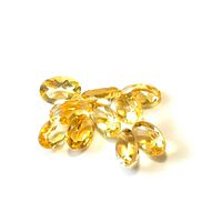 Multiple oval cut yellow-orange citrine gemstones on white background, showing faceting and clarity.