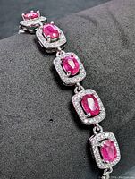 Close-up of linked ruby segments of the sterling silver bracelet showing detail of rubies and clear stones.