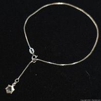 Full view of the sterling silver 9 inch anklet with star-shaped CZ charm, showing clasp and chain detail.
