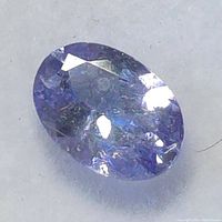 Close-up of the oval tanzanite gemstone showing facets and color.