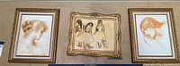 Full view of the three framed art prints hung on a wall, depicting female portraits and ballerinas.