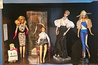 All five dolls displayed side by side on shelving