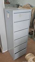 Side and front views of the tall light gray dresser showing all 6 drawers and scuffs on surface