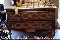 Front elevation showing two drawers with gold leaf laurel wreath carvings and round knob pulls