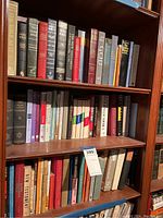 Bookshelves with three rows of religious books including Bibles and theological studies. Various Bible editions and study guides are visible.