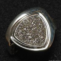 Close-up of the silver ring with triangular gray druzy stone showing sparkling crystal texture.