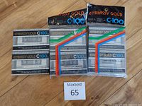 Five Embassy Gold C-100 audio cassette tapes sealed in original packaging, three individually sealed and two sealed together in cellophane with colored stripes. The tapes and packaging appear new and unopened.