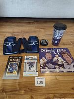 Full view of all items including gloves, puck, cards, book and mug laid on wooden table