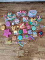 Overview of all Polly Pocket playsets and accessories spread on floor showing scale and quantity