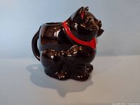 Full side view of the vintage Shefford black cat creamer showing shape and glossy finish.
