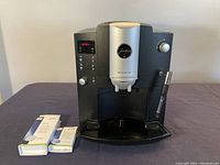 Front view of Jura Impressa E8 machine with cleaning and descaling tablets in front