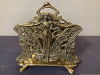 Front view of the solid brass Art Nouveau letter holder showing the central female figure and intricate curved designs.