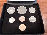 Top view of seven Canadian coins displayed in black case, showing different denominations and finish.