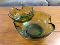 Two-piece green glass chip and dip bowl set shown on wooden surface with no visible chips or damage, edges are wavy and rounded.
