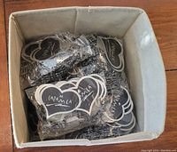 Box containing multiple individually packaged stretch bracelets marked with APANACIA branding on heart-shaped labels.