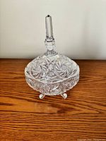 Front view of the intact lead crystal covered candy dish with lid on, showing detailed cut glass patterns and polished knob