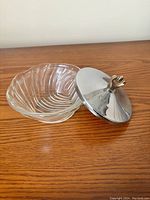 Clear glass bowl paired with a stainless steel lid featuring a decorative knob.