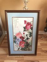 Front view of wood framed and matted floral print with Asian script and red seal.