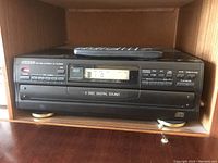 Front view of CITIZEN five disc CD changer showing control buttons, digital display, and disc tray.