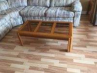 View of the coffee table from an angle showing the three glass panels in the wooden frame.