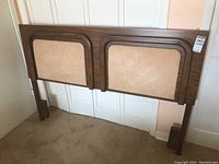 Front view of the wood and fabric headboard showing the two large fabric panels and wooden frame details.