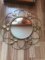 Full mirror showing the floral metal frame and clear reflective surface.
