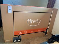 Unopened 50-inch Fire TV 4K box with two Amazon Smart Plug boxes displayed in front