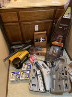 Photo showing Bissell upright carpet cleaner, Eureka Might Mite vacuum, hoses, wand attachments, cleaning solution bottles, and case with handheld steam cleaner.