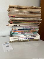 Stack of vintage comic books and comic strip books with two hardcover Calvin and Hobbes and one large Superman history book at the bottom.